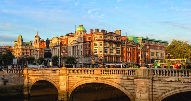Historic stone bridge and ornate buildings along Dublin’s riverfront bathed in warm light.