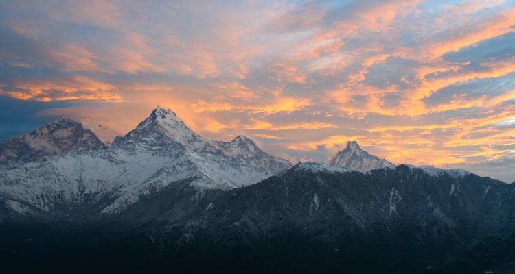 Dramatischer Sonnenuntergang über schneebedeckten Bergen.