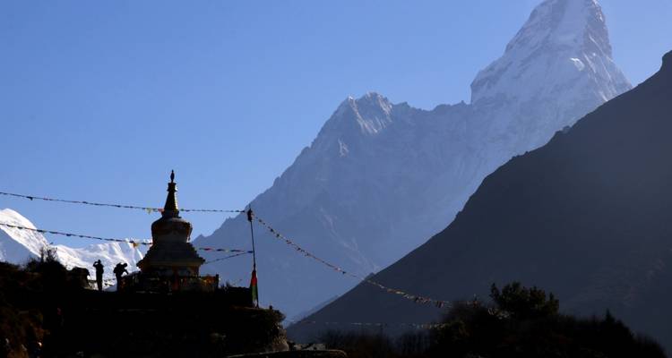 Silhouette of a stupa against a mountain backdrop.