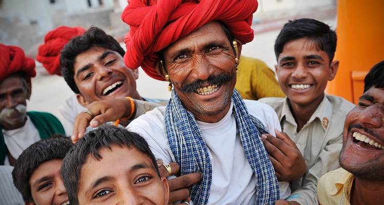 Eine Gruppe lächelnder Menschen in farbenfroher Kleidung.