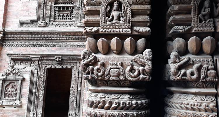 Close-up of elaborate stone and brick carvings featuring deities and ornate columns.