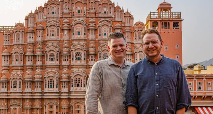 Two men posing in front of the intricate facade of Hawa Mahal.