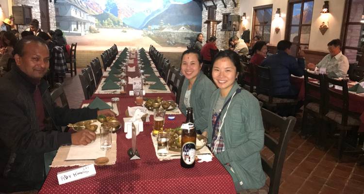 Personas sentadas en una mesa de comedor larga en el interior.