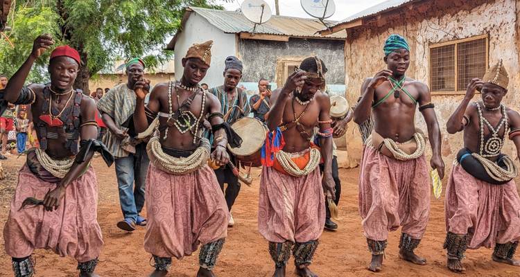 Un grupo de personas con vestimenta tradicional africana realizando una danza.