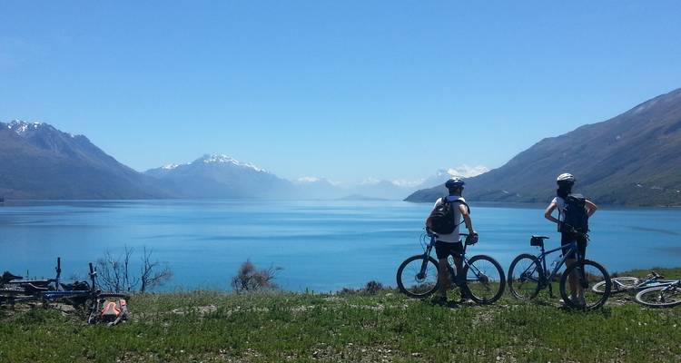Mountainbiker blicken auf einen malerischen See.