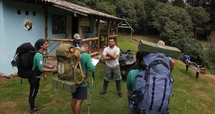 Groep wandelaars met rugzakken verzameld in de buitenlucht.