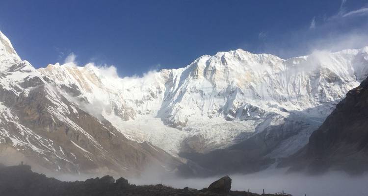 Panoramic view of snow-covered mountains under a clear blue sky.