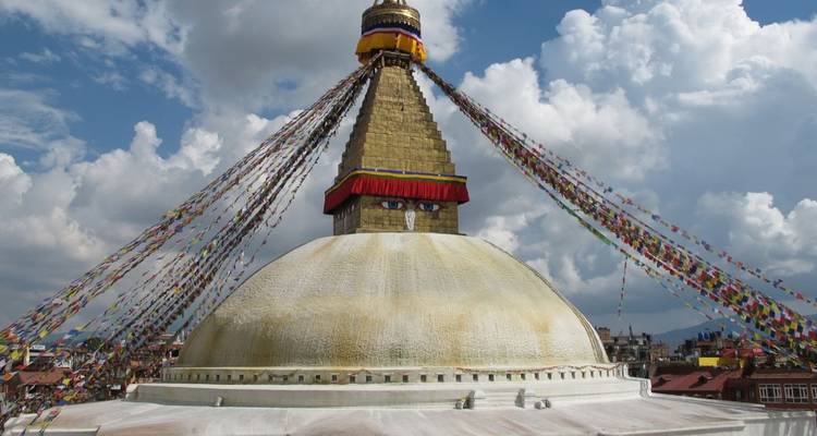 Eine große Stupa mit aufgemalten Augen und nach außen gespannten Gebetsfahnen.