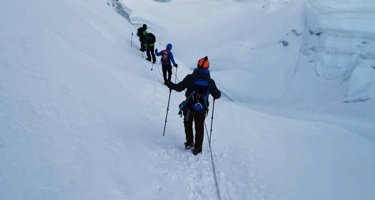 Fila de montañistas caminando por la nieve.