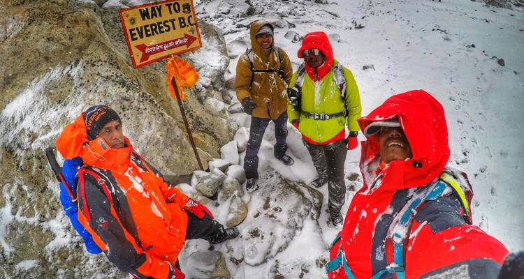 Grupo de excursionistas con equipo de invierno en una señal nevada de "Camino al Everest".