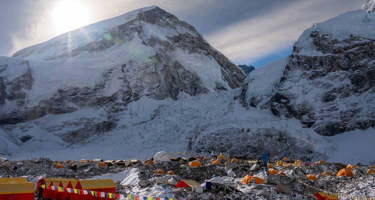 Campamento base con tiendas coloridas bajo picos montañosos helados.