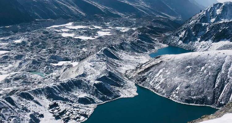 Vista aérea de montañas cubiertas de nieve y lagos azules.