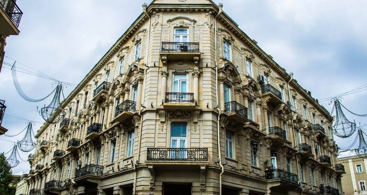 Elegant corner building with decorative balconies.