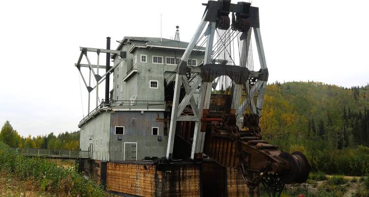 Drague historique utilisée pour l'exploitation minière, située dans une zone forestière.