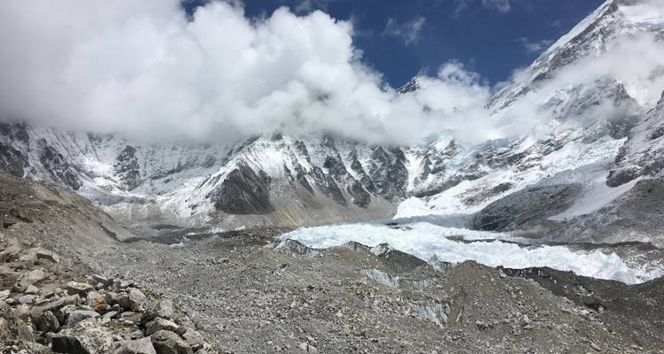 Pics enneigés et nuages dans une région montagneuse.