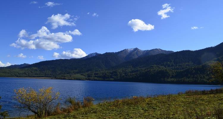 See mit Bergen unter einem klaren blauen Himmel