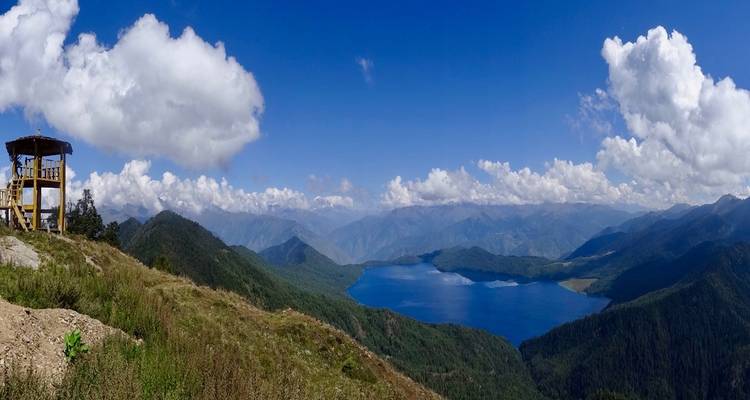 Panoramalandschaft mit See und Bergen unter Wolken