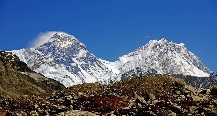 Zwei schneebedeckte Berggipfel unter einem klaren blauen Himmel.
