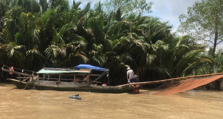 Langes Boot mit Fischernetzen auf einem Fluss.