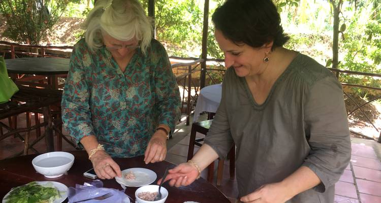 Zwei Frauen bereiten im Freien Essen zu.