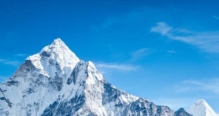 Majestic snowy peaks against a vibrant blue sky.