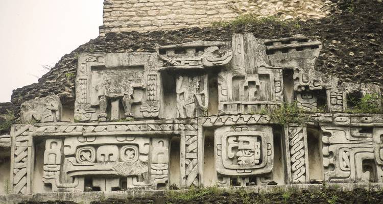 Plan large d'une frise de temple maya ornée enchâssée dans le flanc d'une pyramide de pierre.