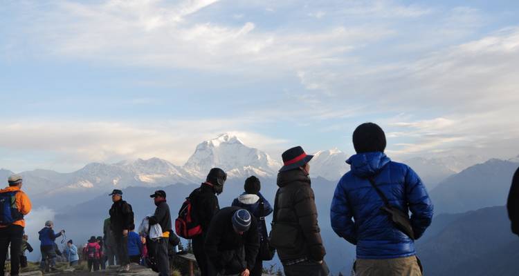 La gente se reunió en la cima de una colina con vistas panorámicas de las montañas.