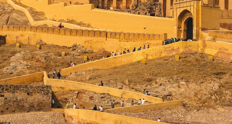 Mensen die wandelen door het Amber Fort met zijn gele muren.