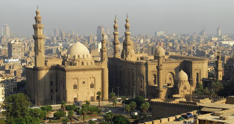 View of an ancient mosque with a cityscape backdrop.