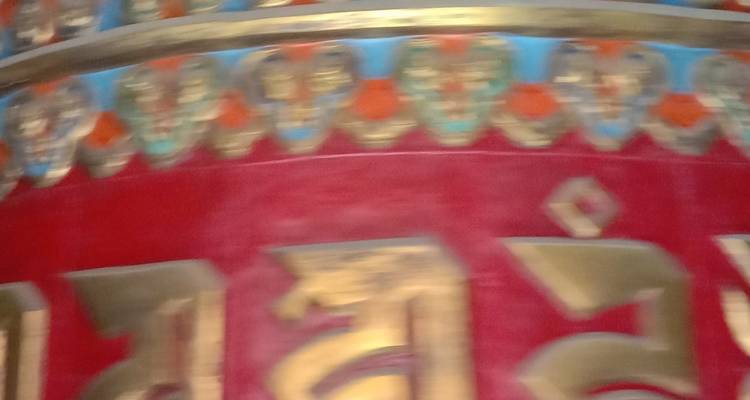 Primer plano de una rueda de oración decorativa desenfocada.