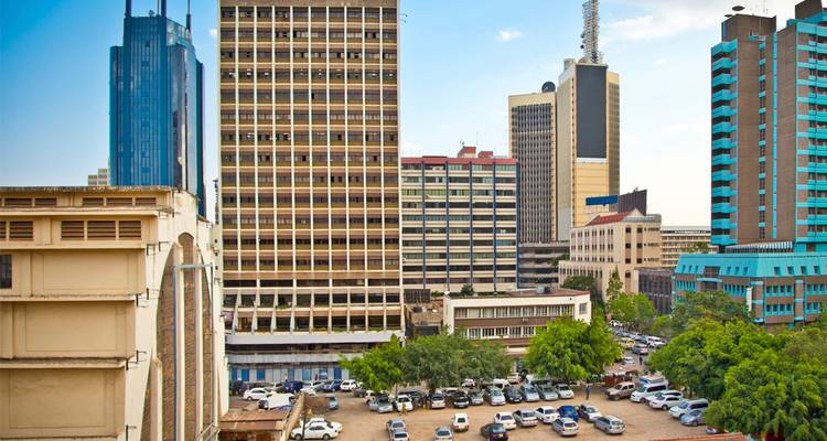 Paisaje urbano de Nairobi con modernos rascacielos y un estacionamiento lleno de autos