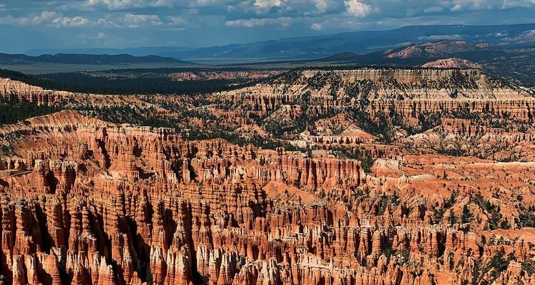 Amfitheater van vurige oranje hoodoos en plateaus strekt zich uit over Bryce Canyon.