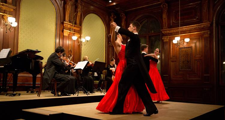 Couples dansant sur scène avec un orchestre en représentation.