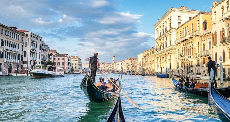 Gondoliers navigate traditional gondolas along Venice’s Grand Canal beneath elegant palaces.