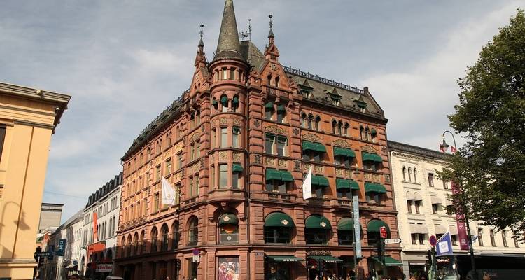 Historic red brick building with detailed architecture and green awnings.