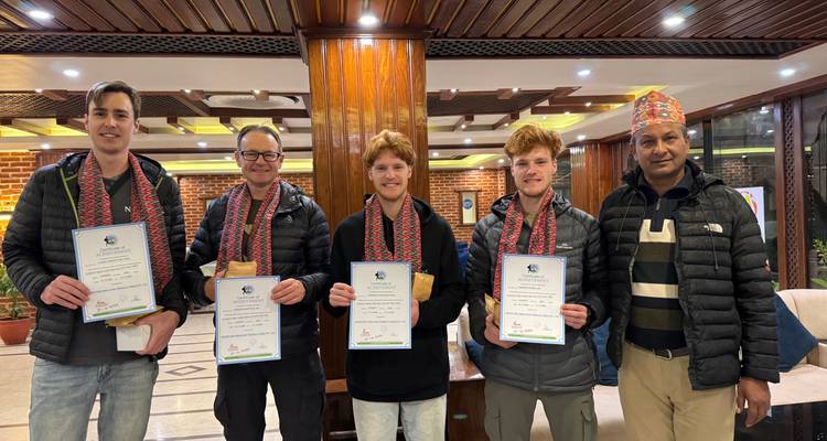 Foto grupal en interiores con personas sosteniendo certificados.