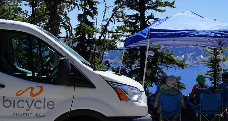 Un van avec des bicyclettes garées près d'un lac pittoresque.
