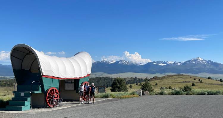 Wagon and cyclists with scenic mountain views.
