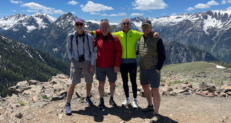 Group of men posing on mountain lookout.