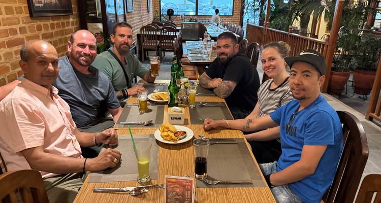 Seis personas cenando y disfrutando bebidas en un restaurante.