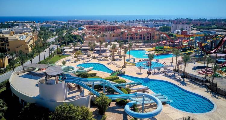 Un complexe hôtelier avec piscines et vue sur la mer.