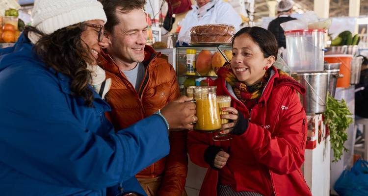 Group of people enjoying juice at a market.