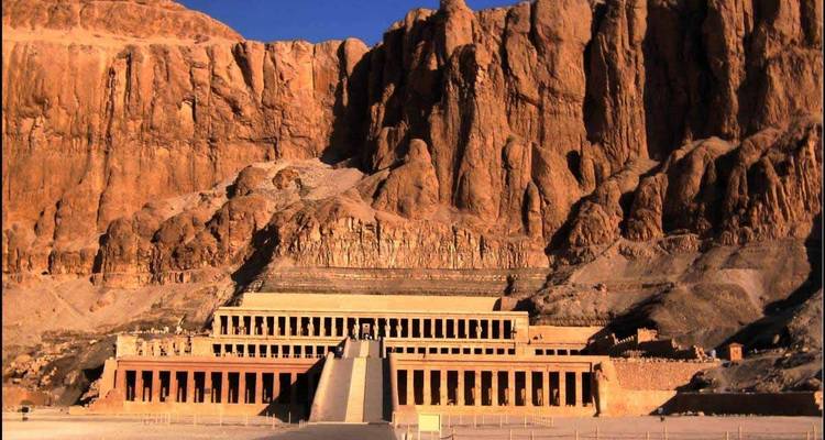 Temple structure against a cliff with rocky background.