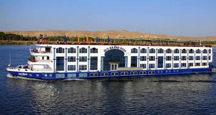 Large river cruise boat on calm water.