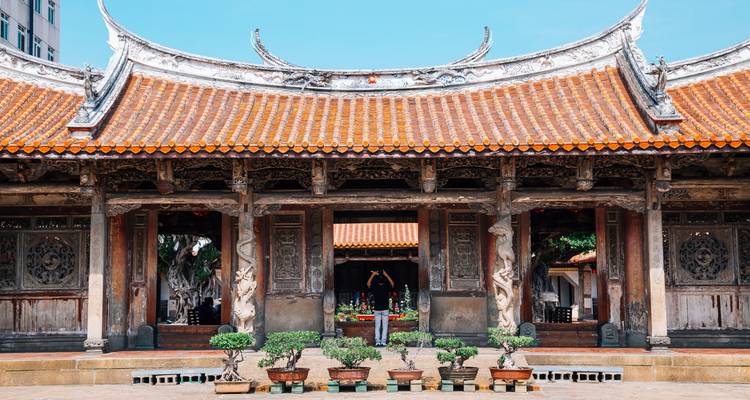 Traditional Taiwanese temple with intricate carvings and bonsai plants.