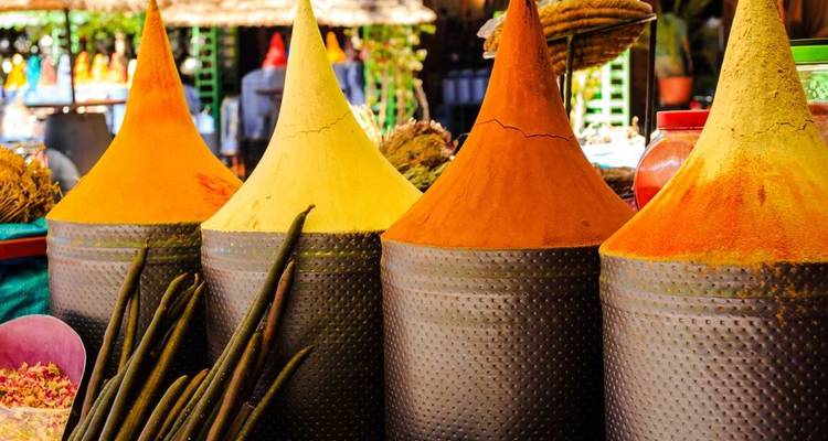 Conos de especias de colores expuestos en un mercado.