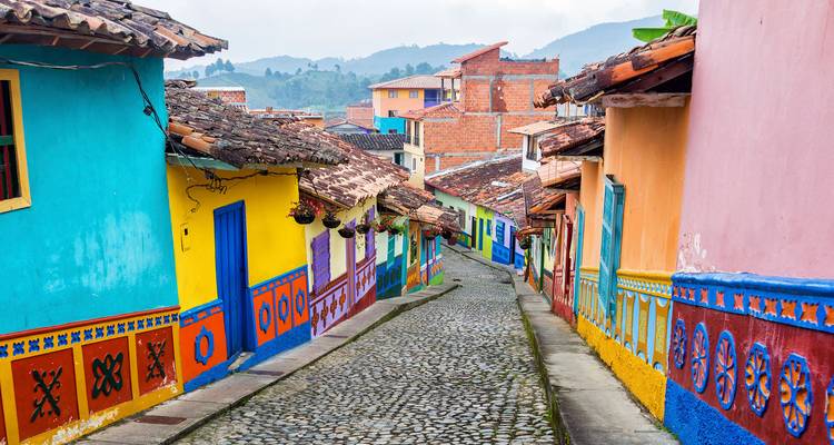 Lebhafte Kopfsteinpflasterstraße in Guatapé, gesäumt von farbenfrohen Häusern und Wandmalereien