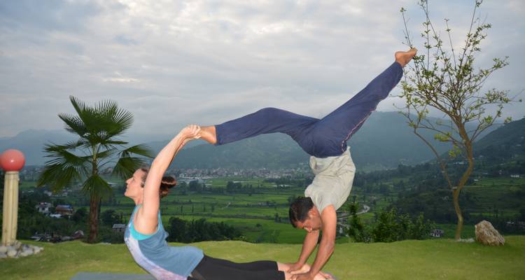 Yoga-Partner beim Acro-Yoga mit Blick auf das Tal.