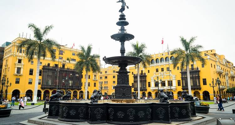 Plaza con edificios coloniales amarillos y fuente, Lima, Perú.