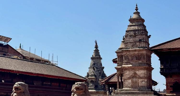 Boudhanath-Stupa mit kunstvoller Bildhauerarbeit vor einem klaren Himmel.